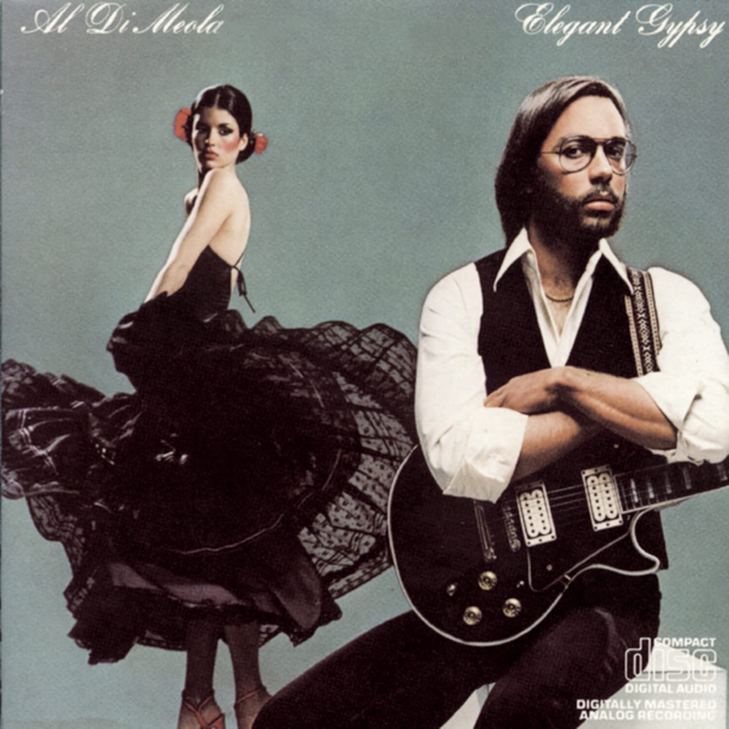 Album cover of "Elegant Gypsy" by Al Di Meola. A beautiful Gypsy lady is dancing in a long black dress while Al poses with his guitar
