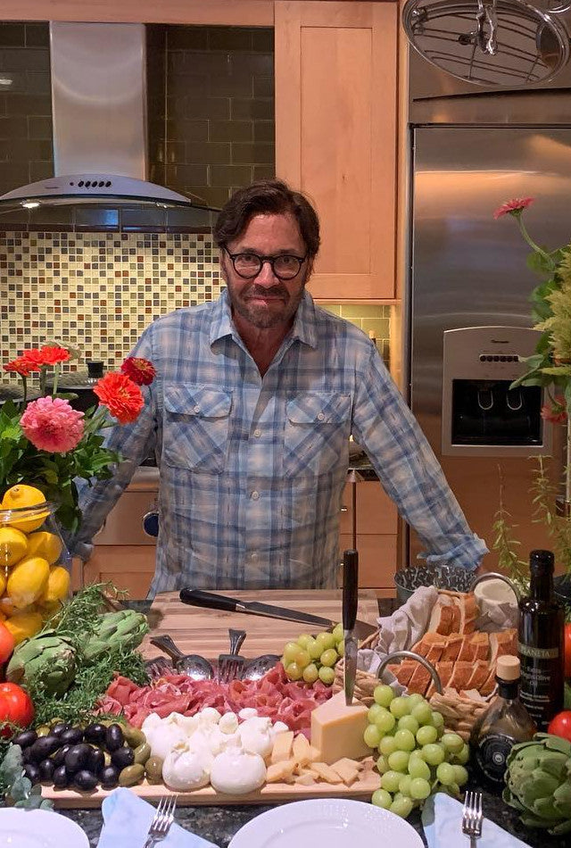 Al Di Meola at his house in New Jersey with a beaufifully arranged mix of home cooked Italian food. The  table is prepared with ham, mozarella, bread, olive oil, grapes, wine and lemons creating a colourful and delicious setting for an exclusive home event